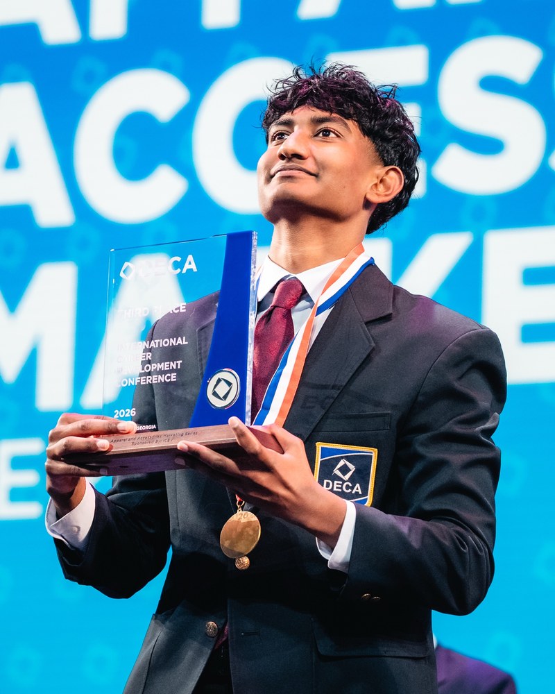 Rohan Arun holding a DECA third place trophy
